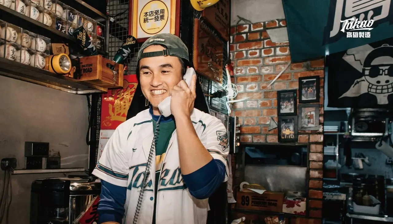 勇記無敵蘿蔔糕老闆洪政勇於高雄店內，店內陳列多項棒球收藏，展現長期關注棒球與基層運動的日常現場
